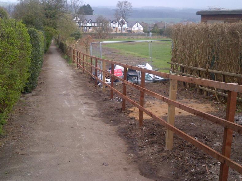 Timber fence replaced and small site compound remains until the gate is installed.