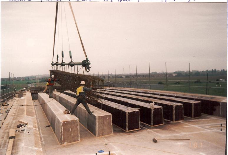 Steel reinforcement being lifted in between void formers on the deck.